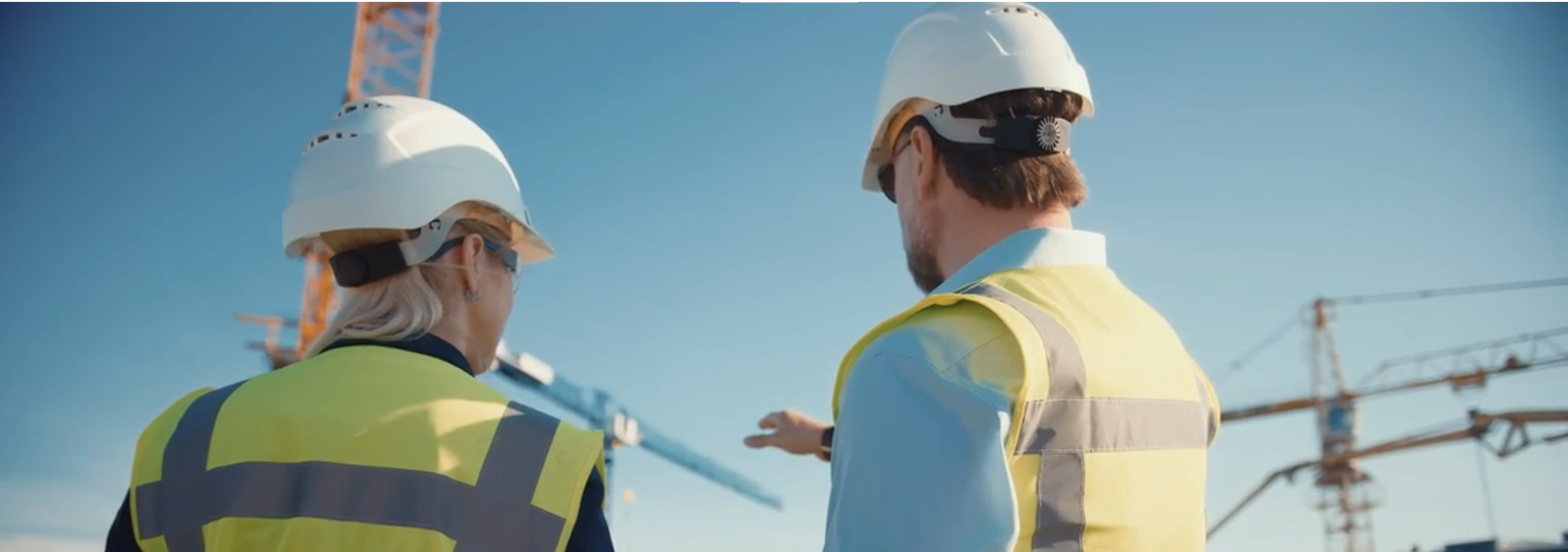 Two construction workers looking hopefully towards the
