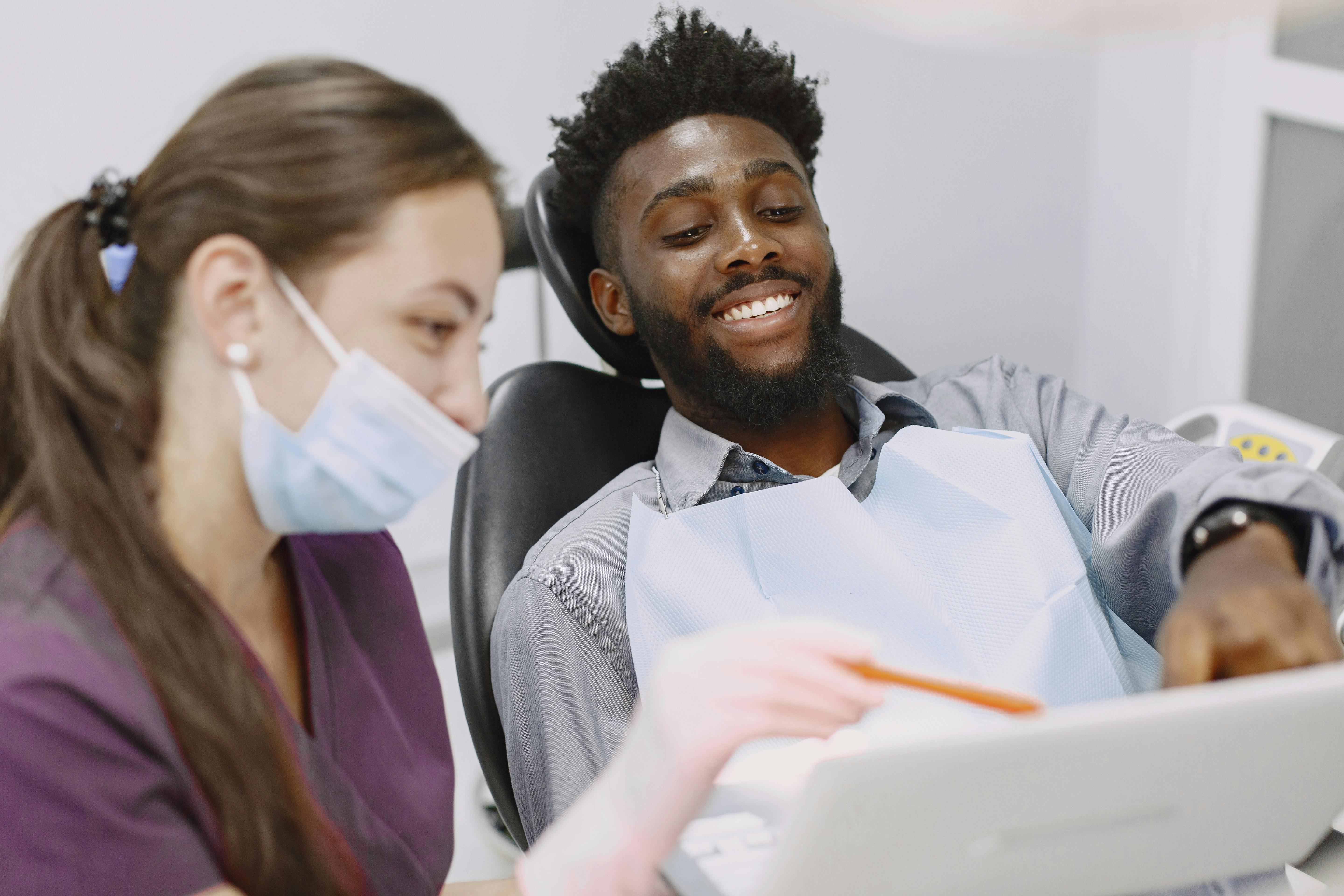 A patient being shown information on a tablet from a dental practitioner.